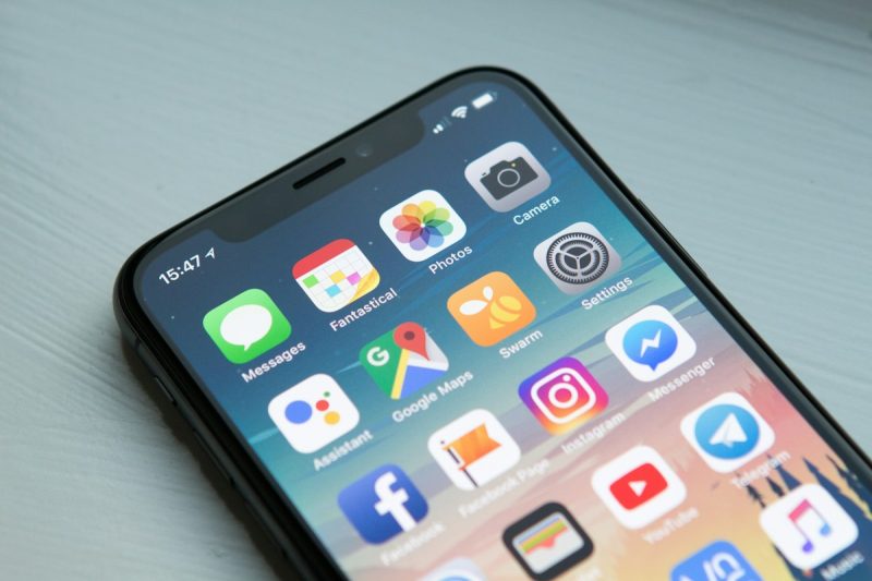 Mobile app engineer testing fintech application on iPhone in modern software lab